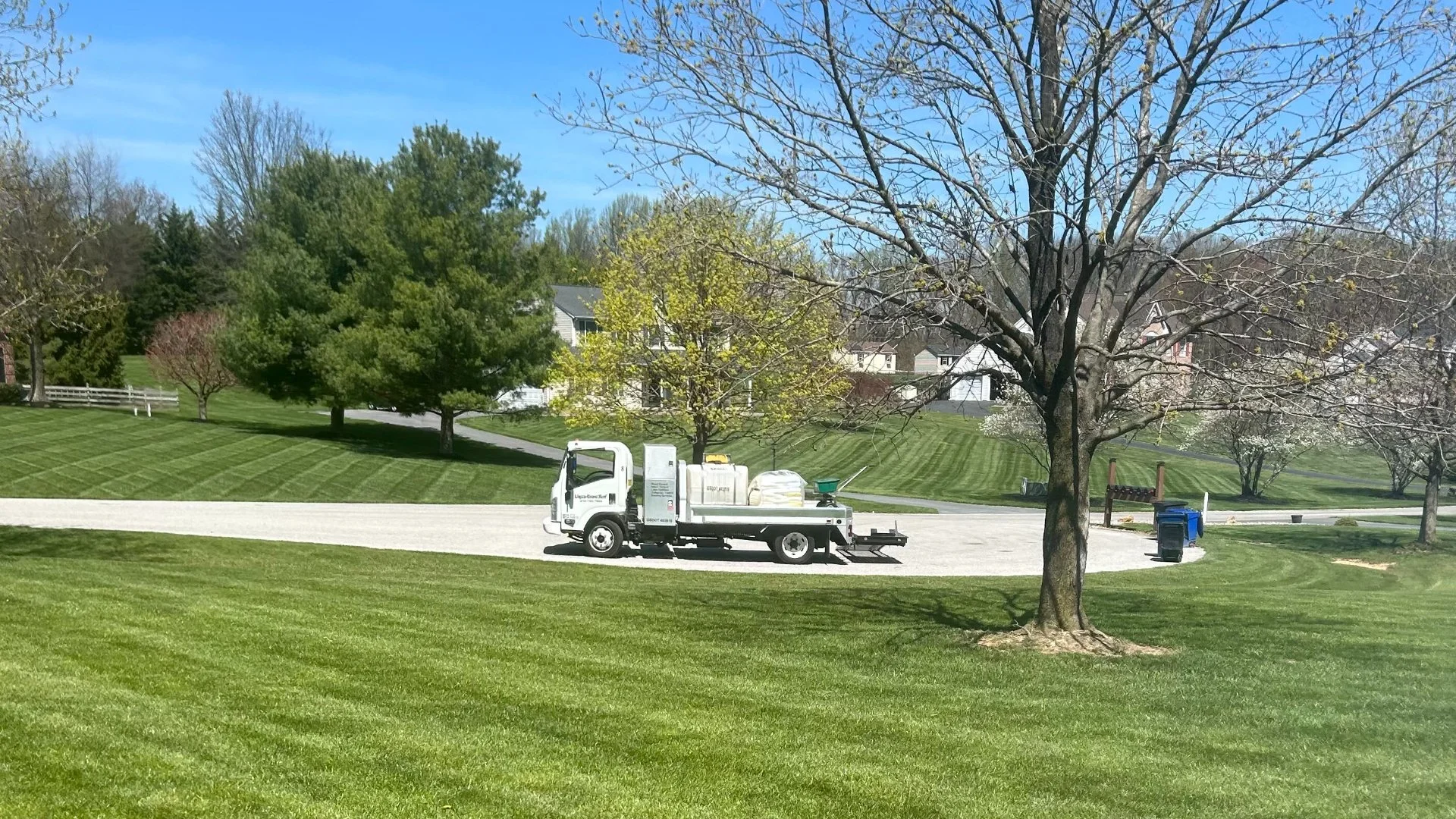 White truck in front of green lawn.