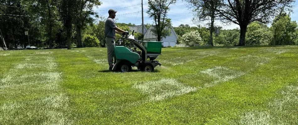 Lawn in Westminster, MD, being treated by a tech on a spreader.