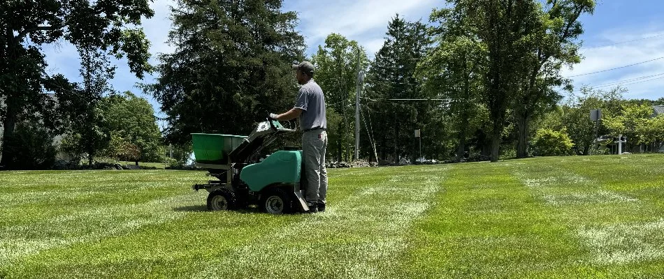 Lawn care crew fertilizing green grass in Milford Mill, MD.