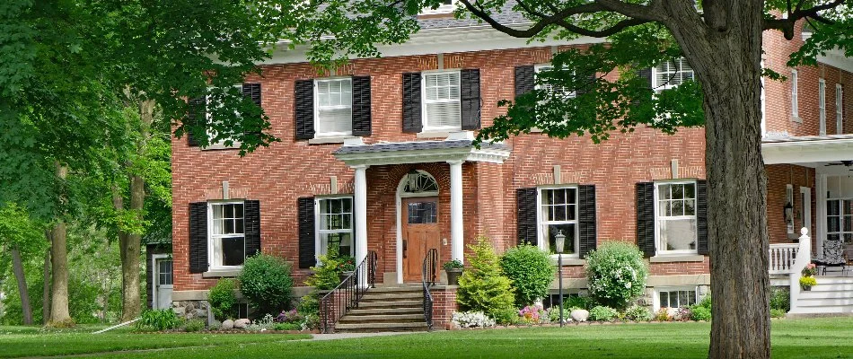 House in Clarksburg, MD, with large trees and shrubs.