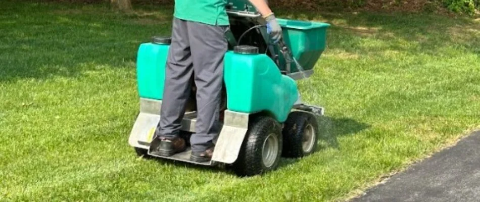Worker applying weed control treatment to lawn in Westminster, MD.
