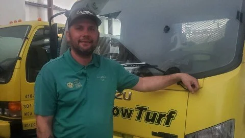Liqua-Grow Turf employee in front of lawn care truck.